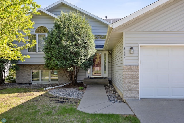 3138 25th Ave S, Fargo, ND 58103 - property entrance with brick siding, a garage, and a yard