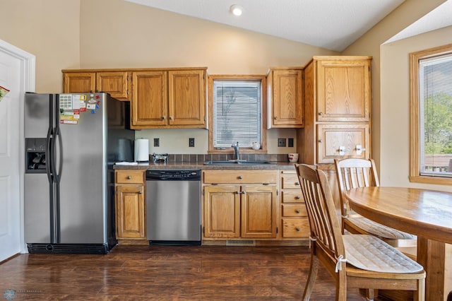 3138 25th Ave S, Fargo, ND 58103 - kitchen with stainless steel appliances, vaulted ceiling, a sink, dark wood-type flooring, and dark countertops