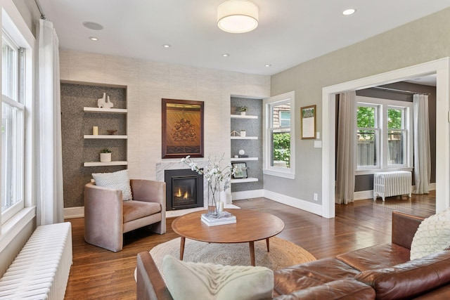 1617 Franklin Ave, Minneapolis, MN 55405 - living area featuring radiator, baseboards, dark wood-style flooring, a glass covered fireplace, and recessed lighting