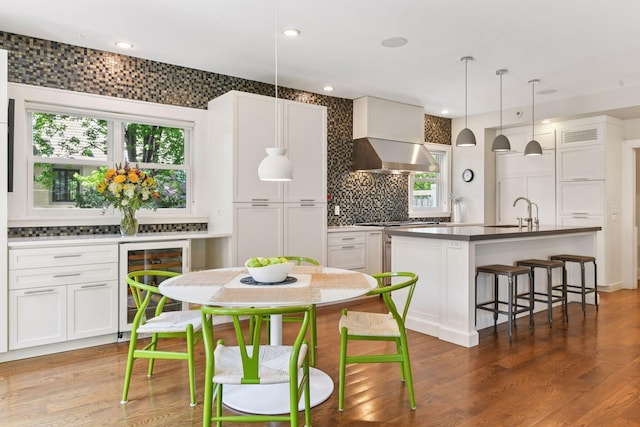 1617 Franklin Ave, Minneapolis, MN 55405 - kitchen featuring wine cooler, exhaust hood, backsplash, a sink, and healthy amount of natural light