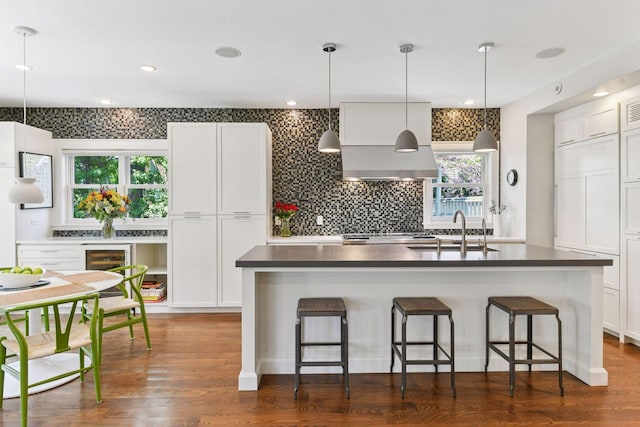 1617 Franklin Ave, Minneapolis, MN 55405 - kitchen with a sink, white cabinets, dark countertops, decorative backsplash, and a kitchen breakfast bar