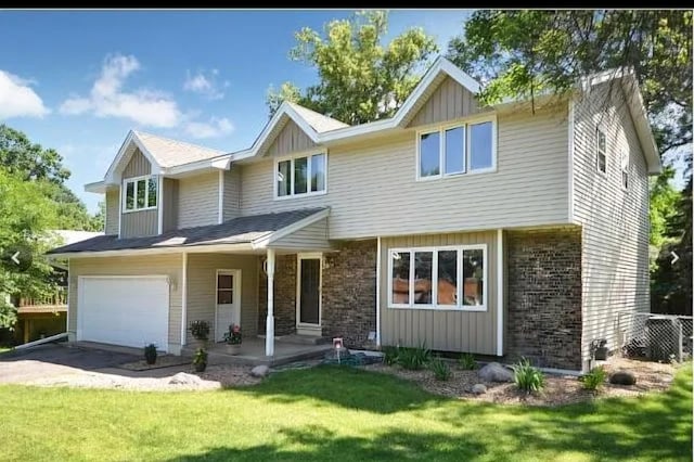 2904 Silver Lake Ct NE, Saint Anthony, MN 55421 - view of front of home with a front lawn, concrete driveway, a garage, brick siding, and board and batten siding
