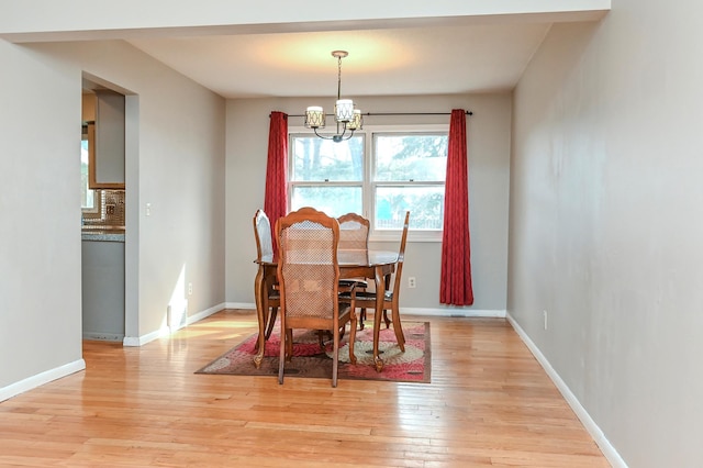 2904 Silver Lake Ct NE, Saint Anthony, MN 55421 - dining area featuring a chandelier, light wood-type flooring, and baseboards