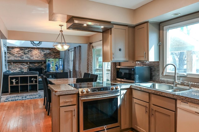 2904 Silver Lake Ct NE, Saint Anthony, MN 55421 - kitchen featuring stainless steel appliances, a sink, ventilation hood, a peninsula, and decorative light fixtures