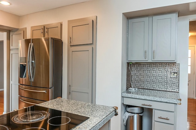 2904 Silver Lake Ct NE, Saint Anthony, MN 55421 - kitchen with stainless steel fridge with ice dispenser, decorative backsplash, black electric stovetop, gray cabinets, and light stone counters