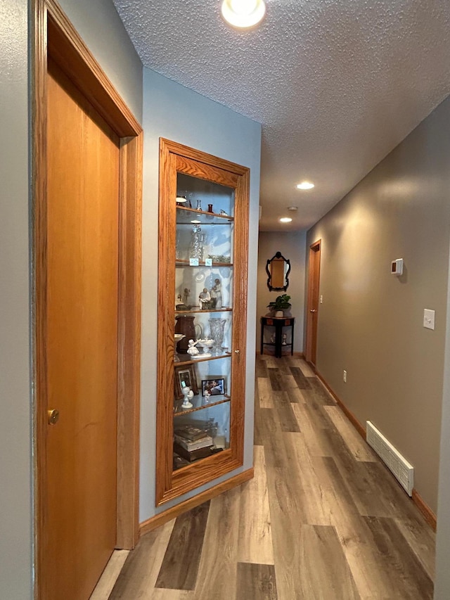 33617 Charlie Trapp Rd, Dent, MN 56528 - hall with wood finished floors, a textured ceiling, baseboards, and recessed lighting