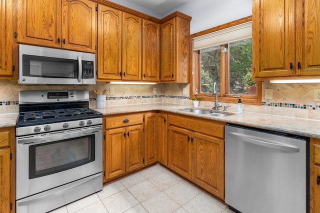 1212 Mill Creek Cir, Saint Cloud, MN 56303 - kitchen with appliances with stainless steel finishes, brown cabinetry, and light stone countertops