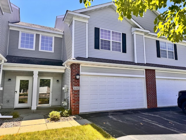 16895 78th Pl N, Maple Grove, MN 55311 - view of front facade featuring an attached garage, brick siding, and driveway