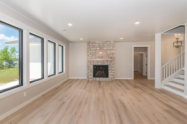 29655 E Horseshoe Lake Rd, Mission Twp, MN 56465 - unfurnished living room featuring light wood-type flooring, stairway, recessed lighting, a stone fireplace, and baseboards