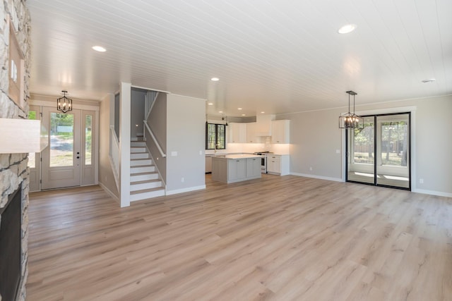 29655 E Horseshoe Lake Rd, Mission Twp, MN 56465 - unfurnished living room with a chandelier, a stone fireplace, light wood-style flooring, recessed lighting, and wooden ceiling