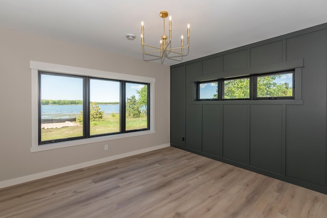 29655 E Horseshoe Lake Rd, Mission Twp, MN 56465 - unfurnished room with a chandelier, light wood finished floors, baseboards, and a water view