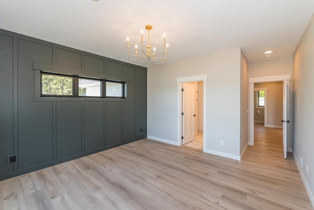 29655 E Horseshoe Lake Rd, Mission Twp, MN 56465 - unfurnished bedroom featuring a chandelier, light wood-style flooring, and baseboards