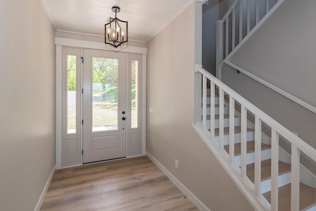 29655 E Horseshoe Lake Rd, Mission Twp, MN 56465 - entrance foyer featuring stairway, light wood-style flooring, a chandelier, baseboards, and crown molding