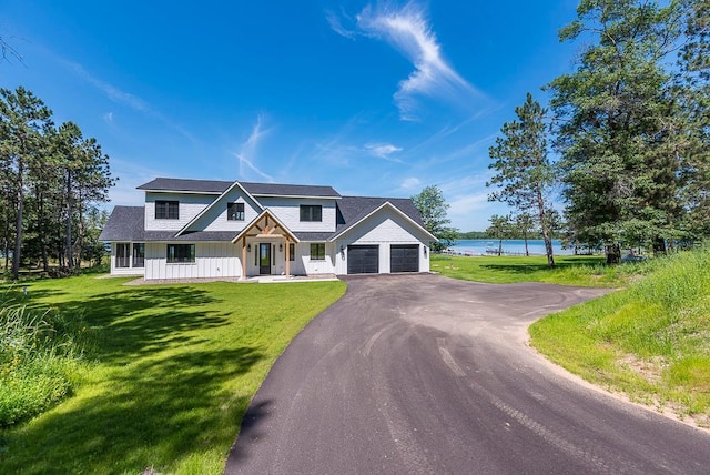 29655 E Horseshoe Lake Rd, Mission Twp, MN 56465 - modern farmhouse with a garage, asphalt driveway, a water view, and a front lawn