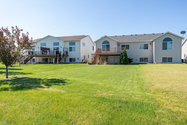 828 Cinnamon Ridge Pl, West Fargo, ND 58078 - rear view of house featuring stairway, a wooden deck, and a lawn