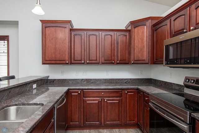 828 Cinnamon Ridge Pl, West Fargo, ND 58078 - kitchen featuring appliances with stainless steel finishes, dark stone counters, hanging light fixtures, and dark brown cabinets