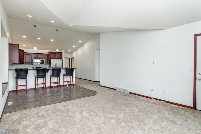 828 Cinnamon Ridge Pl, West Fargo, ND 58078 - kitchen with stainless steel appliances, vaulted ceiling, carpet floors, recessed lighting, and a breakfast bar area