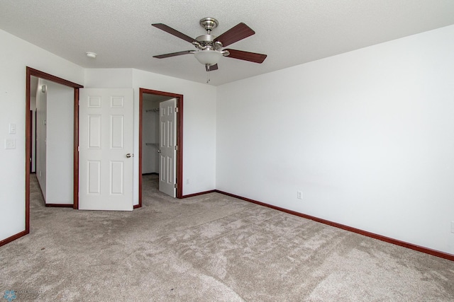 828 Cinnamon Ridge Pl, West Fargo, ND 58078 - unfurnished bedroom featuring carpet flooring, a spacious closet, baseboards, a ceiling fan, and a textured ceiling