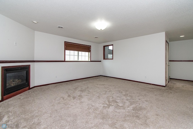 828 Cinnamon Ridge Pl, West Fargo, ND 58078 - unfurnished living room with carpet, baseboards, a glass covered fireplace, and a textured ceiling