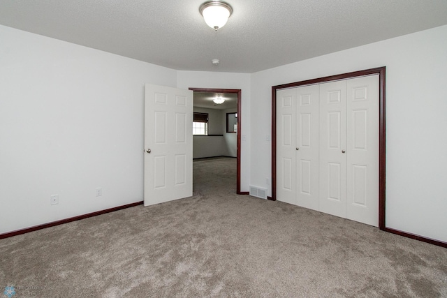 828 Cinnamon Ridge Pl, West Fargo, ND 58078 - unfurnished bedroom with carpet floors, a closet, a textured ceiling, and baseboards