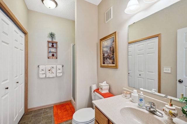 17830 Glasgow Way, Lakeville, MN 55044 - bathroom featuring a closet, vanity, toilet, and a shower with shower door