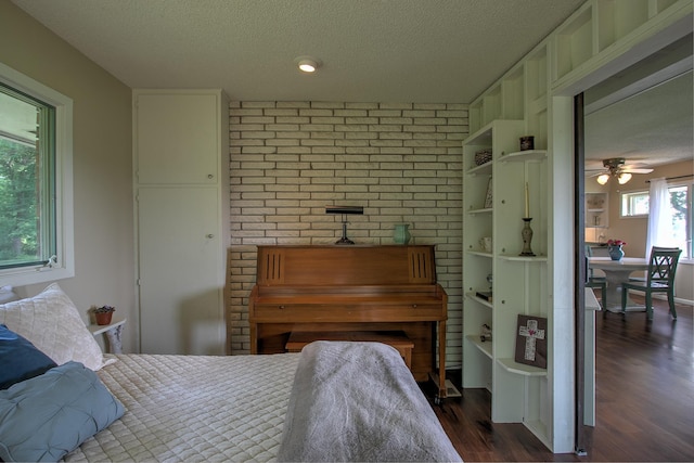 2509 Jade St, Mora, MN 55051 - bedroom with a textured ceiling, dark wood finished floors, and brick wall