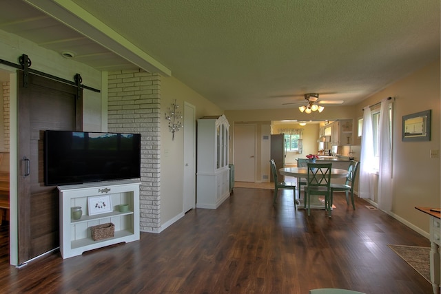 2509 Jade St, Mora, MN 55051 - dining room with dark wood-type flooring, a barn door, ceiling fan, and a textured ceiling