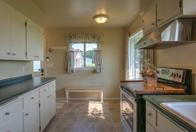 2509 Jade St, Mora, MN 55051 - kitchen featuring stainless steel electric stove, extractor fan, dark countertops, and white cabinetry