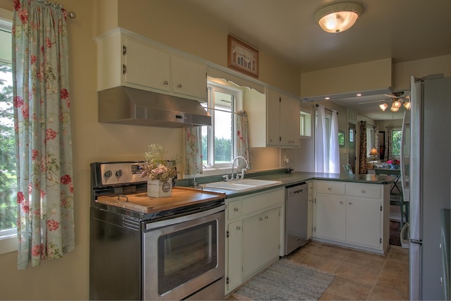 2509 Jade St, Mora, MN 55051 - kitchen featuring appliances with stainless steel finishes, ventilation hood, a peninsula, white cabinets, and ceiling fan