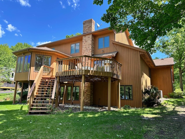 18819 329th Ave, Isle, MN 56342 - rear view of house with a chimney, a deck, stairway, a lawn, and a sunroom
