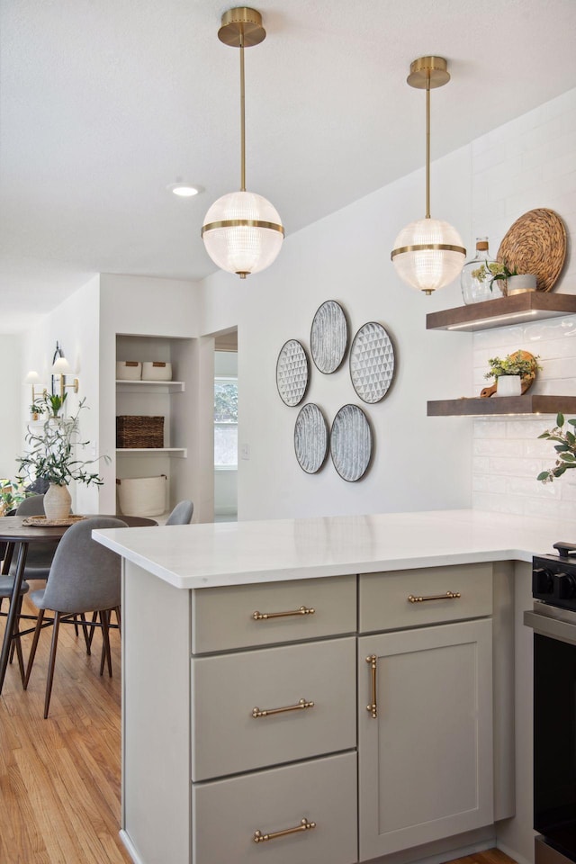 2930 Salem Ave, Saint Louis Park, MN 55416 - kitchen with gray cabinetry, range, light countertops, light wood-type flooring, and pendant lighting