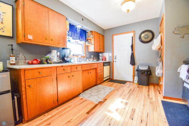 2009 7th St N, Fargo, ND 58102 - kitchen featuring dishwasher, light wood-style floors, light countertops, and brown cabinets