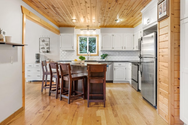 2487 2nd St SW, Buffalo, MN 55313 - kitchen featuring stainless steel appliances, wood ceiling, light wood-style flooring, white cabinets, and tasteful backsplash