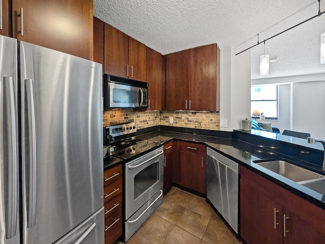 401 1st St Unit 601, Minneapolis, MN 55401 - kitchen with appliances with stainless steel finishes, dark countertops, a textured ceiling, decorative backsplash, and dark tile patterned floors