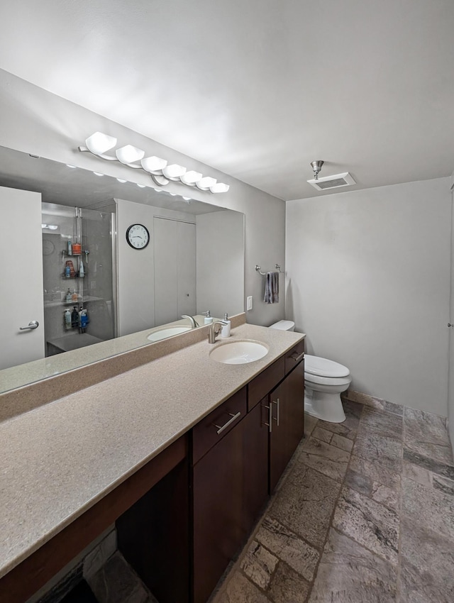 401 1st St Unit 601, Minneapolis, MN 55401 - bathroom featuring stone tile flooring, vanity, a stall shower, and toilet