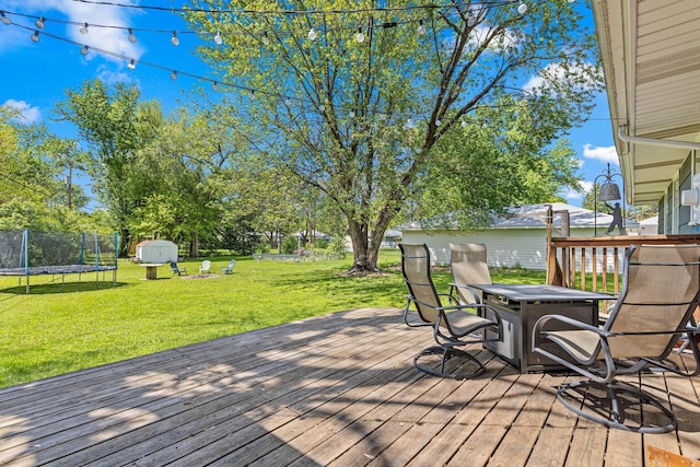 7109 Douglas Dr N, Brooklyn Park, MN 55429 - wooden terrace featuring a trampoline, a lawn, and a fire pit