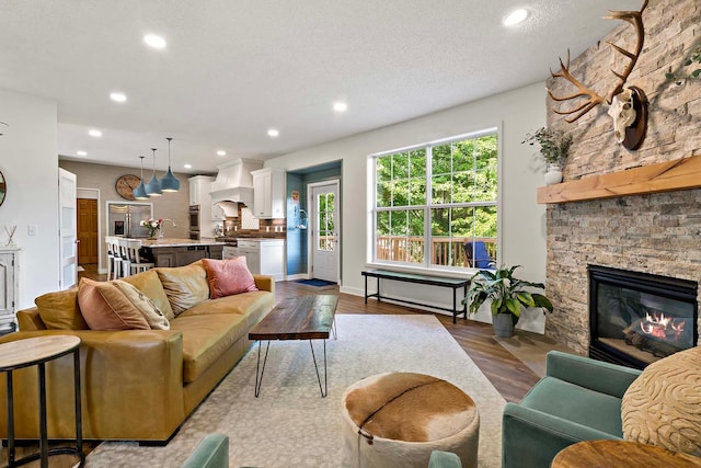 15084 Appaloosa Trl NE, Prior Lake, MN 55372 - living area featuring recessed lighting, wood finished floors, a stone fireplace, and a textured ceiling