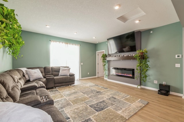 13323 Territorial Cir N, Maple Grove, MN 55369 - living area with wood finished floors, a textured ceiling, a glass covered fireplace, baseboards, and recessed lighting