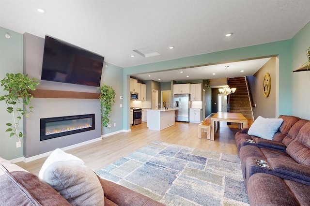 13323 Territorial Cir N, Maple Grove, MN 55369 - living room featuring a glass covered fireplace, light wood finished floors, recessed lighting, a chandelier, and baseboards