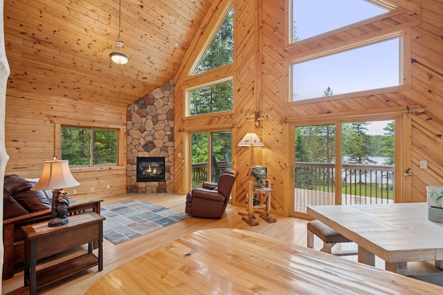 7194 Quentin Rd NE, Outing, MN 56662 - living room featuring high vaulted ceiling, a fireplace, hardwood / wood-style flooring, wood walls, and a water view