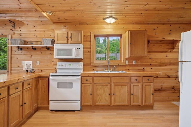 7194 Quentin Rd NE, Outing, MN 56662 - kitchen with white appliances, a sink, light wood-style flooring, light countertops, and wooden walls