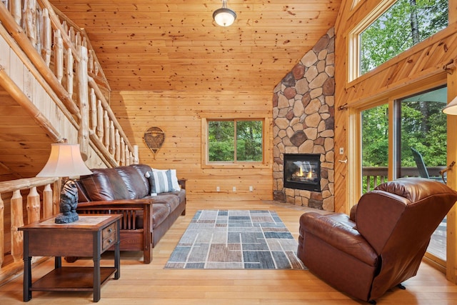 7194 Quentin Rd NE, Outing, MN 56662 - living room featuring wood ceiling, wood finished floors, high vaulted ceiling, a stone fireplace, and wood walls