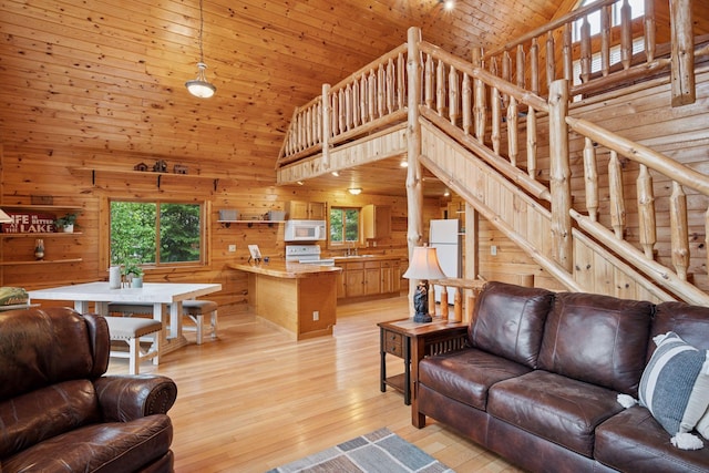 7194 Quentin Rd NE, Outing, MN 56662 - living room featuring high vaulted ceiling, wood walls, stairway, light wood finished floors, and wooden ceiling