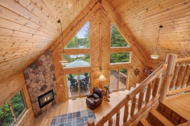 7194 Quentin Rd NE, Outing, MN 56662 - living room with wooden ceiling, high vaulted ceiling, wood walls, a stone fireplace, and wood finished floors