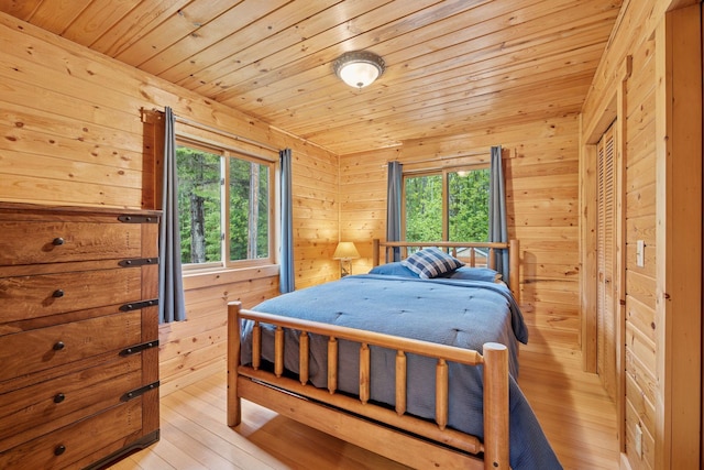 7194 Quentin Rd NE, Outing, MN 56662 - bedroom with multiple windows, wood ceiling, light wood-type flooring, and wood walls