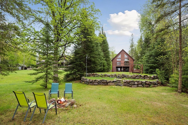 7194 Quentin Rd NE, Outing, MN 56662 - view of green lawn featuring a fire pit and a wooden deck