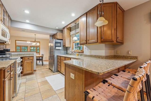 5241 Silver Maple Cir, Minnetonka, MN 55343 - kitchen featuring stainless steel appliances, a peninsula, brown cabinets, hanging light fixtures, and recessed lighting