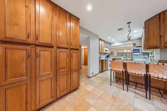 5241 Silver Maple Cir, Minnetonka, MN 55343 - kitchen featuring white appliances, brown cabinets, a peninsula, recessed lighting, and a breakfast bar area