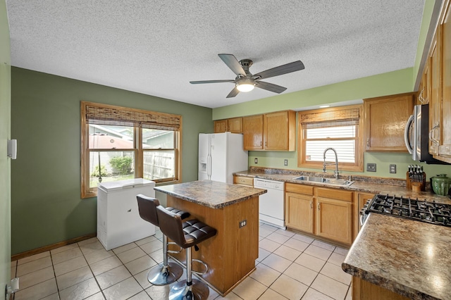 2651 Colfax Ave N, Minneapolis, MN 55411 - kitchen featuring appliances with stainless steel finishes, a center island, a ceiling fan, light tile patterned floors, and a textured ceiling