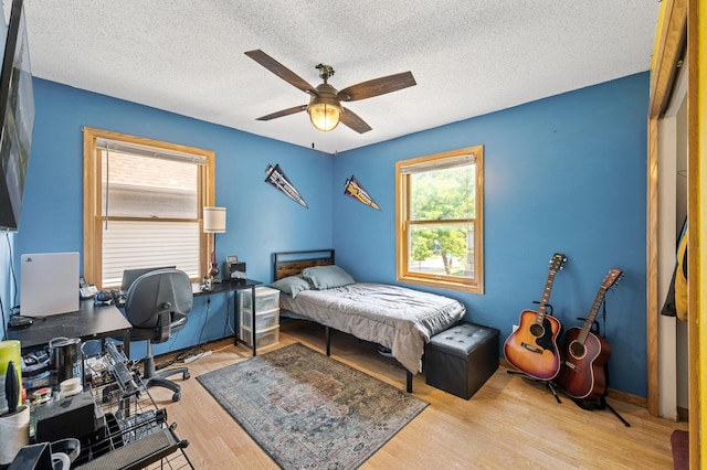 2651 Colfax Ave N, Minneapolis, MN 55411 - bedroom featuring wood finished floors, a textured ceiling, ceiling fan, and an office area